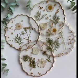 Decorative resin coasters with pressed flowers and gold accents.